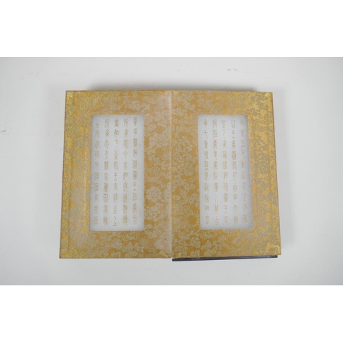 36 - A Chinese wood and material bound book containing white jade tablets with engraved and gilt characte... 