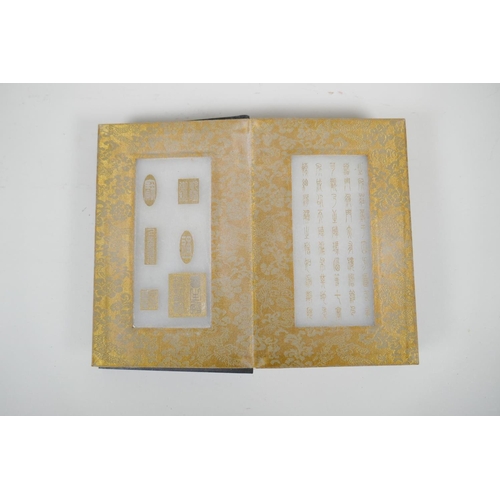 36 - A Chinese wood and material bound book containing white jade tablets with engraved and gilt characte... 