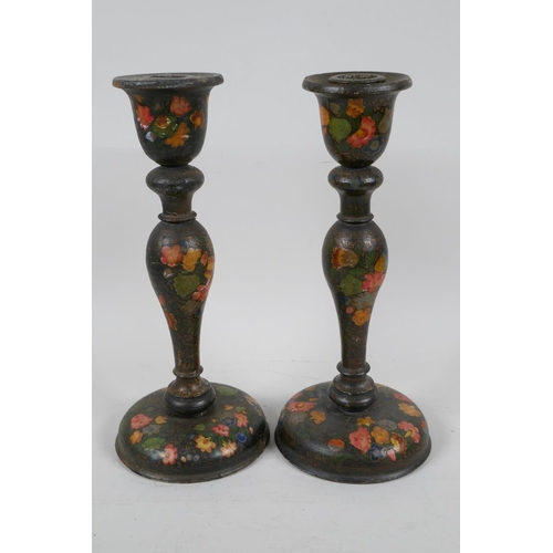 41 - A pair of Kashmiri papier mache candlesticks painted with flowers, 9½