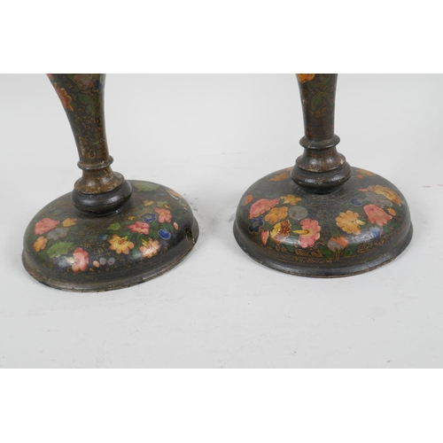 41 - A pair of Kashmiri papier mache candlesticks painted with flowers, 9½