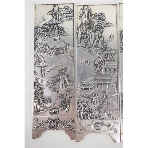 42 - A set of four Chinese white metal scroll weights in the form of screen panels embossed with landscap... 