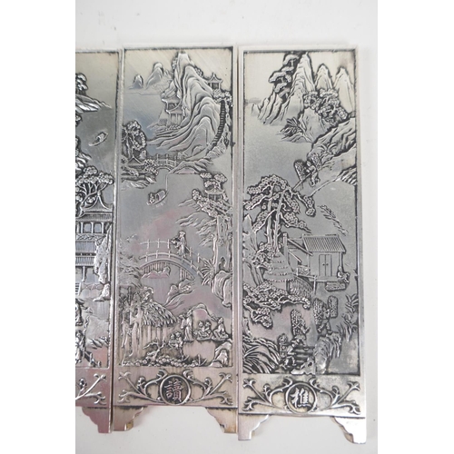 42 - A set of four Chinese white metal scroll weights in the form of screen panels embossed with landscap... 