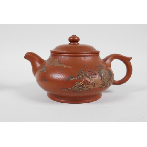 58 - A Chinese Yixing teapot with raised and painted landscape decoration, and another with enamelled pea... 