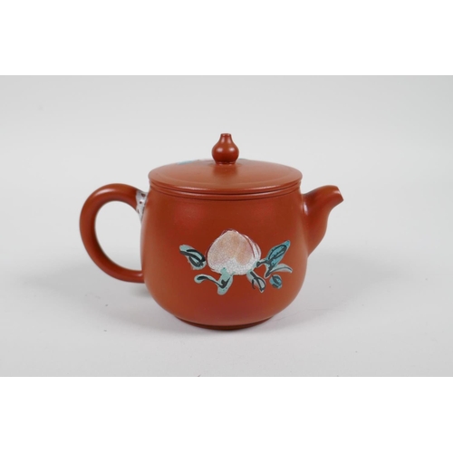 58 - A Chinese Yixing teapot with raised and painted landscape decoration, and another with enamelled pea... 