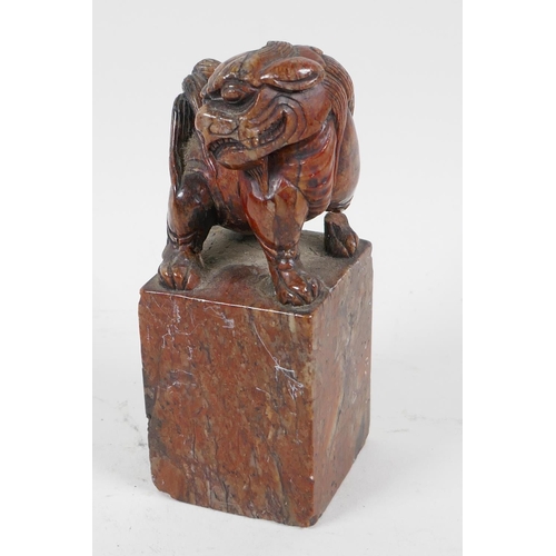 62 - An antique Chinese carved soapstone figure of a kylin standing on a square pedestal, A/F, 5