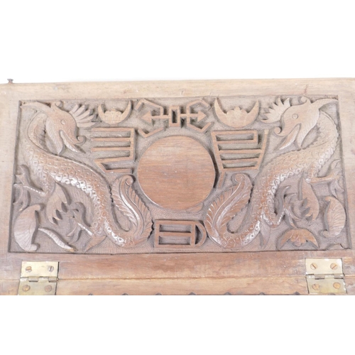 76 - An antique carved wood artist's box, the lid heavily carved with dragons and symbols inside and out,... 