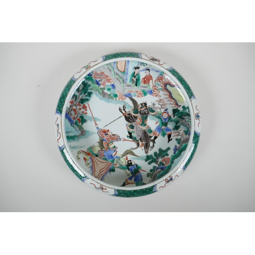 78 - A Chinese famille verte porcelain dish with a rolled rim decorated with warriors on horseback, 6 cha... 