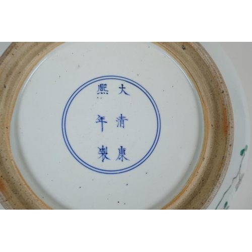 78 - A Chinese famille verte porcelain dish with a rolled rim decorated with warriors on horseback, 6 cha... 