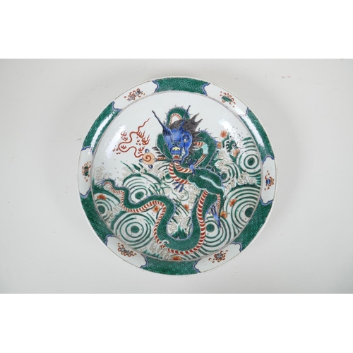 83 - A Chinese famille verte porcelain charger decorated with a dragon and the flaming pearl, 6 character... 