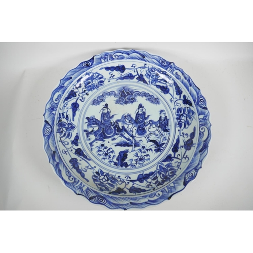 84 - A Chinese blue and white porcelain charger decorated with travellers on horseback, 18½