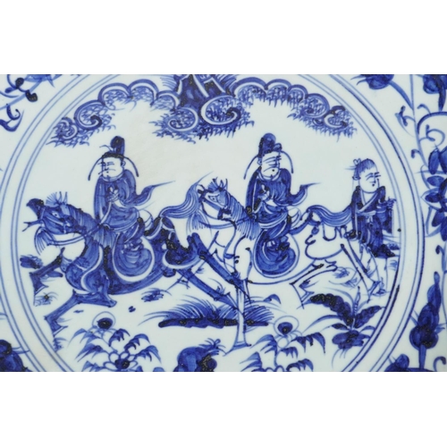 84 - A Chinese blue and white porcelain charger decorated with travellers on horseback, 18½