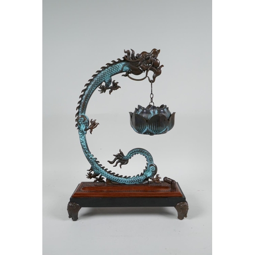 85 - An Oriental hardwood and bronze incense burner of dragon and lotus flower form, 12