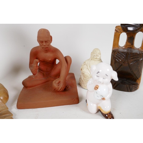 97 - Five figures including red earthenware man, composition Buddha, Hamnet pig figure, Balinese wood pip... 