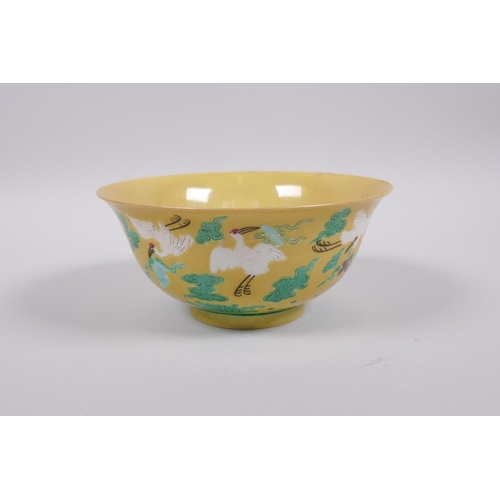 20 - A Chinese yellow ground porcelain rice bowl decorated with red crowned cranes in flight, 6 character... 