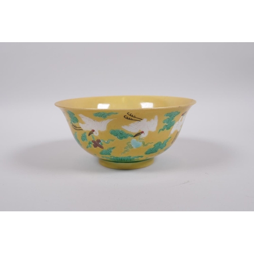 20 - A Chinese yellow ground porcelain rice bowl decorated with red crowned cranes in flight, 6 character... 