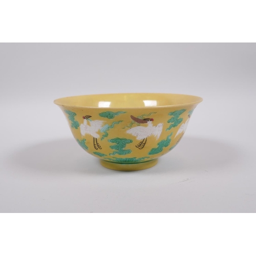 20 - A Chinese yellow ground porcelain rice bowl decorated with red crowned cranes in flight, 6 character... 