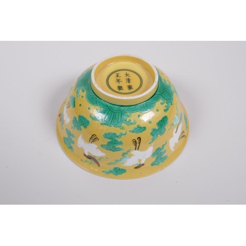 20 - A Chinese yellow ground porcelain rice bowl decorated with red crowned cranes in flight, 6 character... 