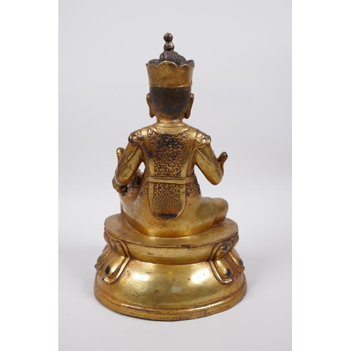 33 - A Tibetan gilt bronze of a deity seated on a lotus throne accompanied by a rat, 10