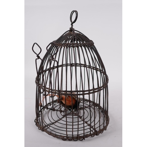 22 - A domed wire bird cage with woven banding, housing a model bird with metal head and feet, 11