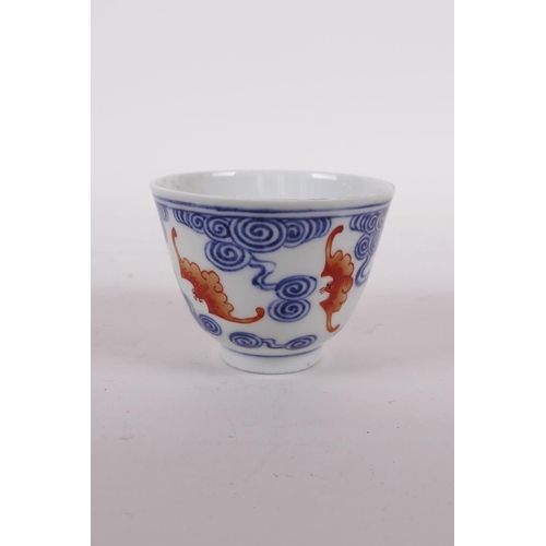 25 - A Chinese blue and white porcelain tea bowl with iron red bat decoration, Quing six character mark t... 