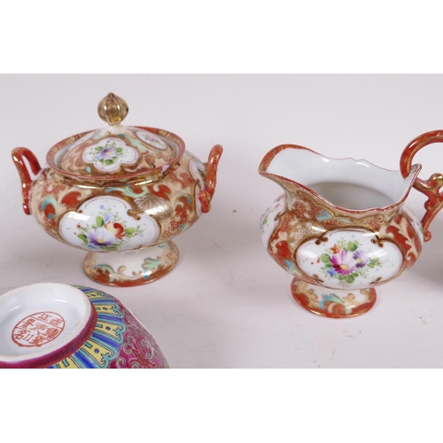 31 - A Noritake porcelain two handled sucrier and cover, painted with flowers and a matching cream jug, t... 