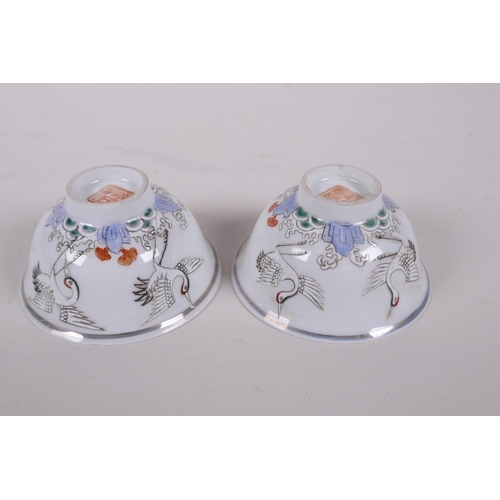 38 - A pair of early C20th Chinese polychrome porcelain tea bowls decorated with cranes, seal mark to bas... 