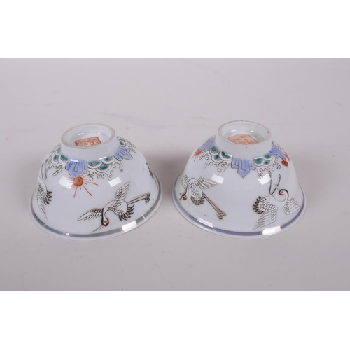 38 - A pair of early C20th Chinese polychrome porcelain tea bowls decorated with cranes, seal mark to bas... 