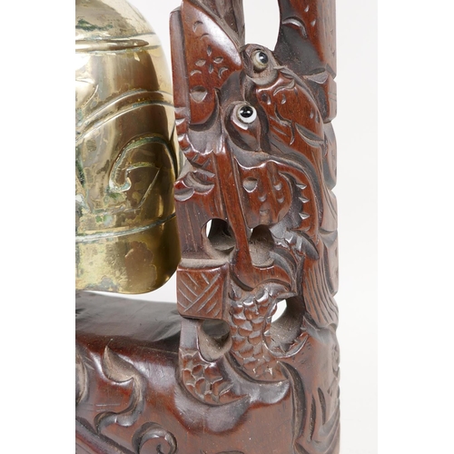 34 - An oriental table gong with hardwood frame carved as dragons around a pagoda, with bell shaped gong,... 