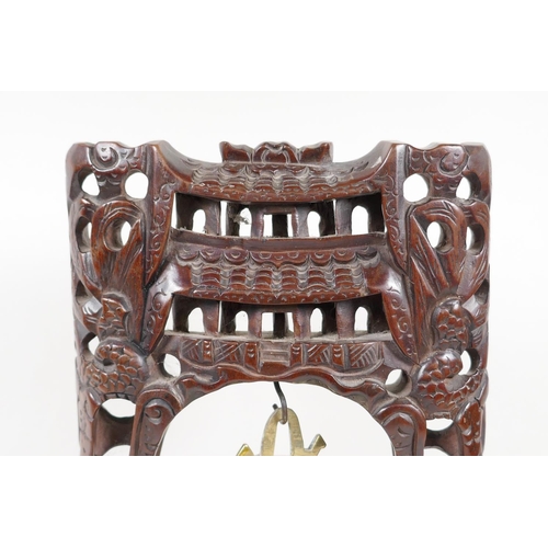 34 - An oriental table gong with hardwood frame carved as dragons around a pagoda, with bell shaped gong,... 