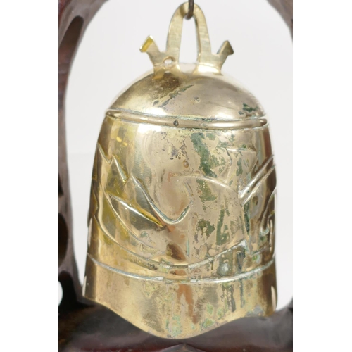 34 - An oriental table gong with hardwood frame carved as dragons around a pagoda, with bell shaped gong,... 