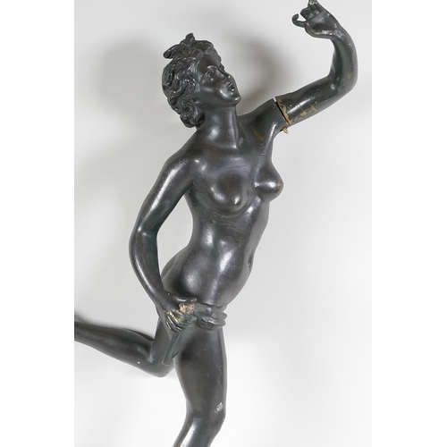 30 - A bronze figurine of a female nude standing on a wheel, 22½