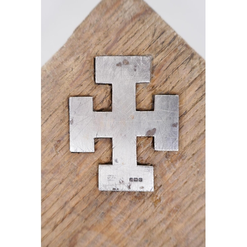 31 - An oak panel with inset hallmarked silver cross potent and the inscription, 