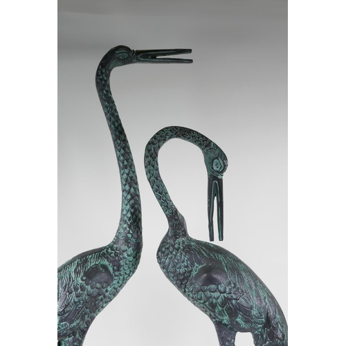 34 - A pair of cast metal garden figures of cranes, largest 33½