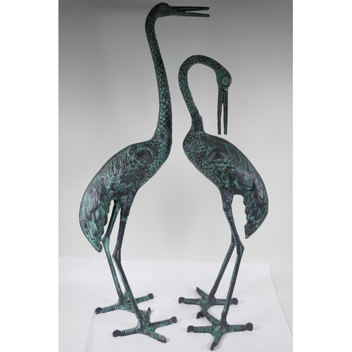 34 - A pair of cast metal garden figures of cranes, largest 33½