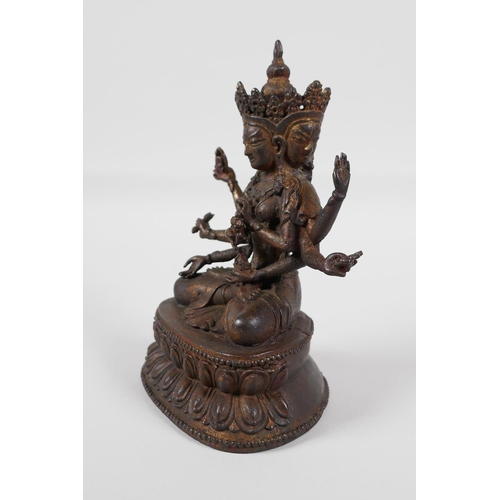 63 - A Sino-Tibetan bronze of a many armed deity, seated on a lotus throne. Carrying auspicious items, wi... 