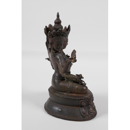 63 - A Sino-Tibetan bronze of a many armed deity, seated on a lotus throne. Carrying auspicious items, wi... 