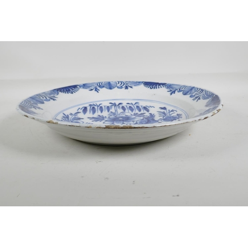 66 - An C18th/C19th Delft blue and white charger with hand painted floral decoration, 14