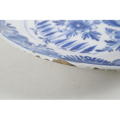 66 - An C18th/C19th Delft blue and white charger with hand painted floral decoration, 14