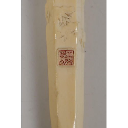 21 - A C19th Japanese carved ivory parasol handle, carved with various figures, signed with red seal mark... 