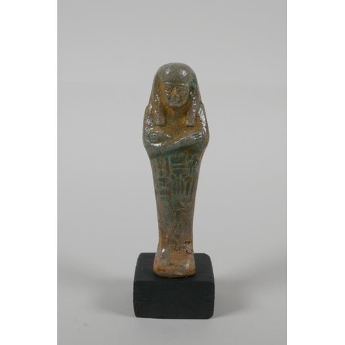 25 - An Egyptian Faience pottery Shabti and a terracotta glazed amulet of Khum, largest 4