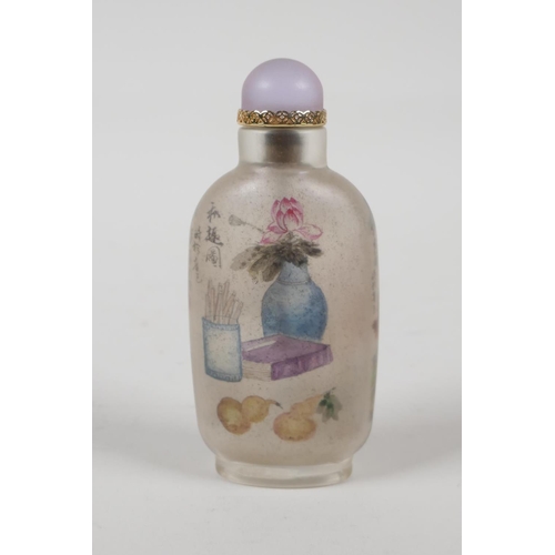 37 - A Chinese reverse decorated glass snuff bottle depicting figures in a river landscape, and scribes e... 