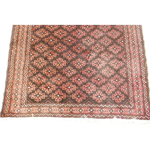 1143 - A hand woven rug with geometric floral design, on a faded red field, 41