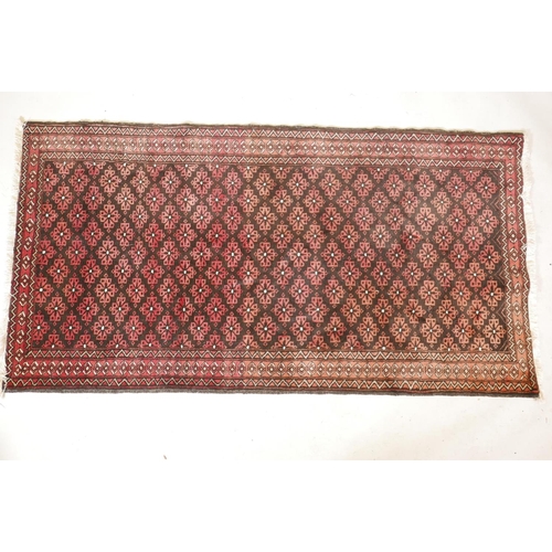 1143 - A hand woven rug with geometric floral design, on a faded red field, 41