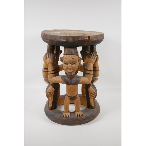 1141 - An African carved and stained wood figural stool, 16½