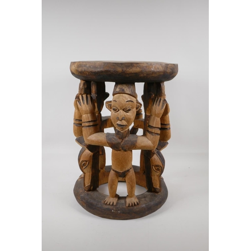 1141 - An African carved and stained wood figural stool, 16½