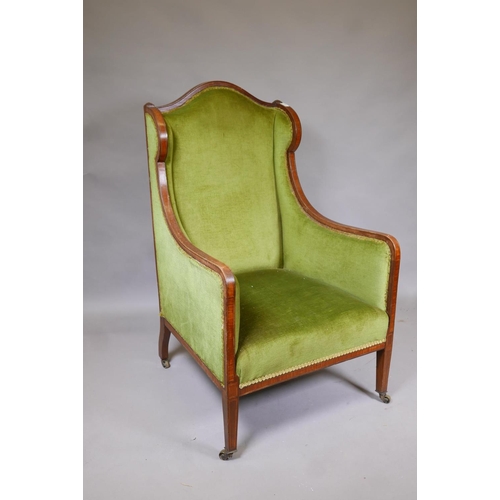 1148 - A Victorian mahogany wingback armchair with green upholstery