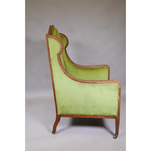 1148 - A Victorian mahogany wingback armchair with green upholstery