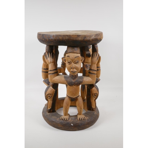 1141 - An African carved and stained wood figural stool, 16½