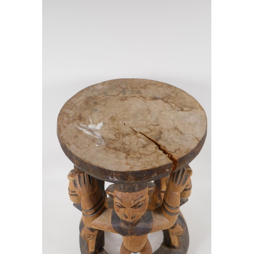 1141 - An African carved and stained wood figural stool, 16½