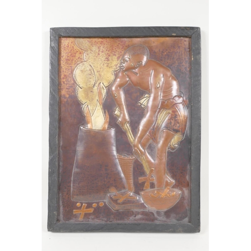 29 - An African embossed copper and brass panel depicting a man stoking a fire barrel, 7